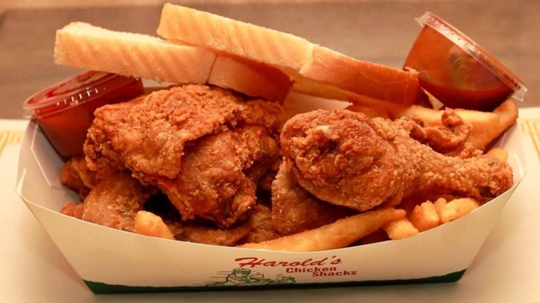 A tray of fried chicken with fries, sauce and bread from Harold's Chicken