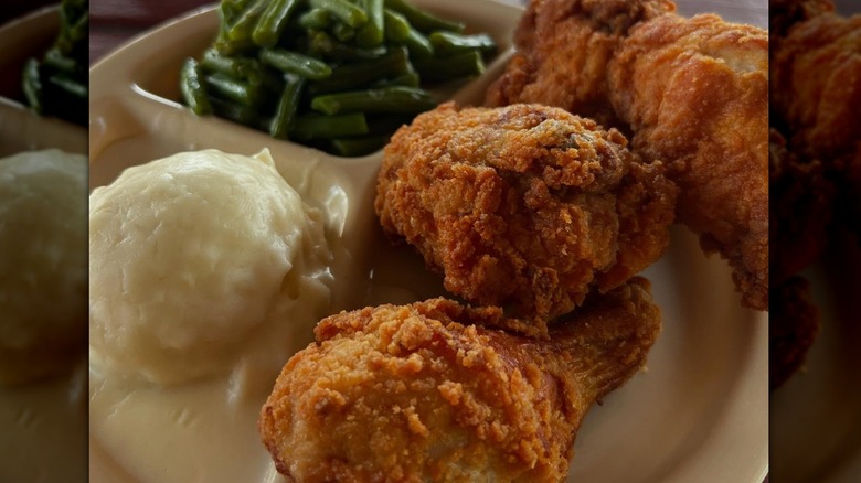 A plate of fried chicken with sides at Chicken Mary's
