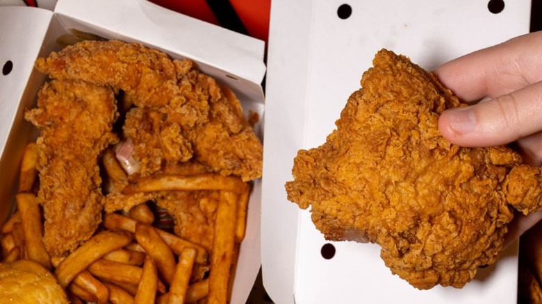 Someone holding a piece of fried chicken from Willie's Chicken Shack