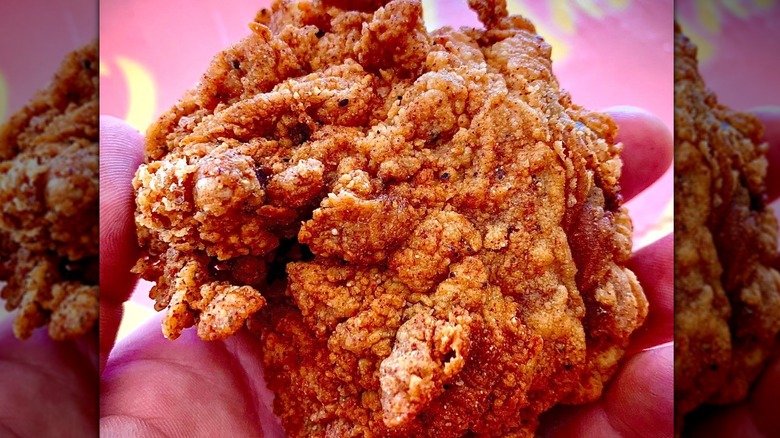 Someone holding a piece of Sweet Chix Kitchen fried chicken