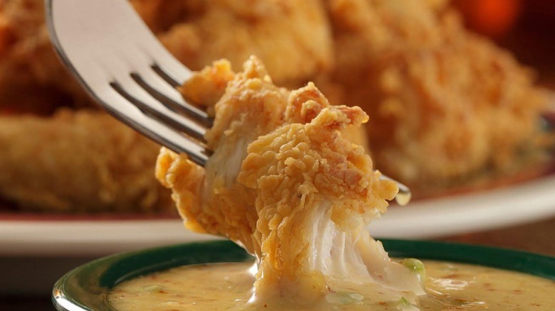 A fork dipping fried chicken from Babe's Chicken Dinner House