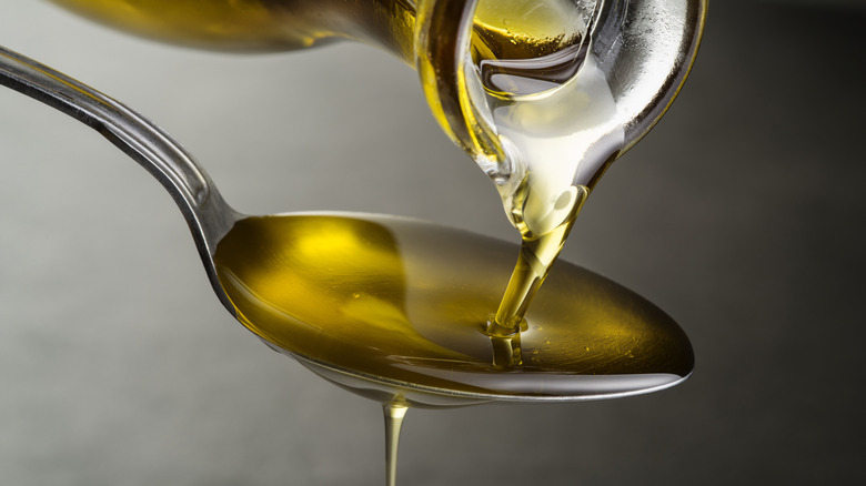 Close-up of oil pouring onto a spoon