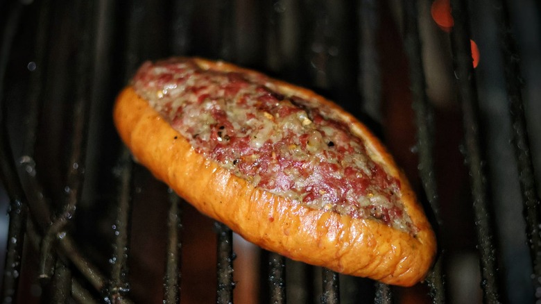 hot dog and beef glizzburger on grill grates