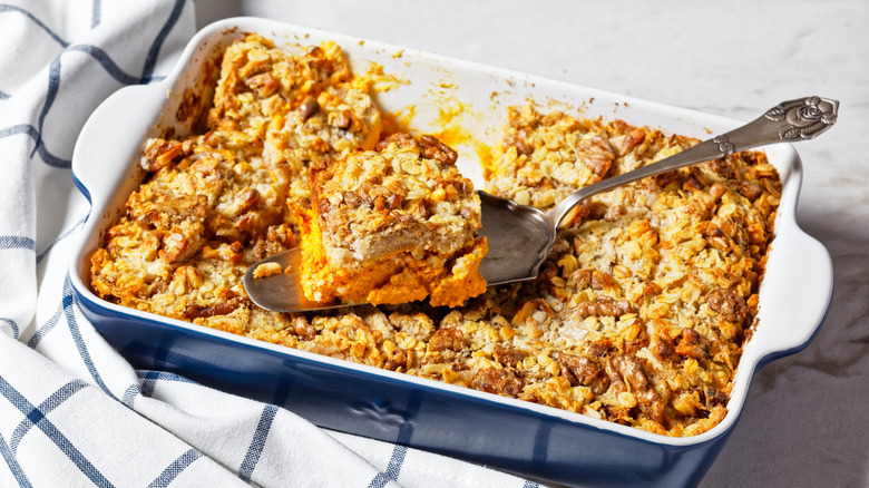 A dump cake served in a blue-and-white pan, with a spoon and cut out piece resting on top