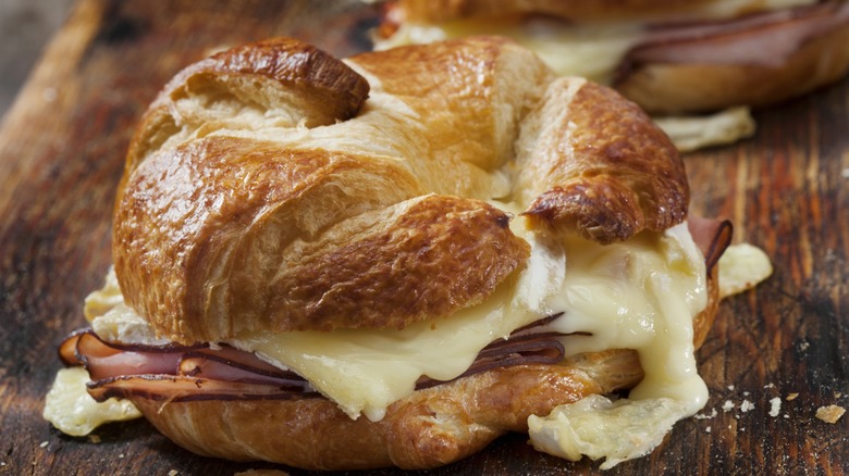 golden brown croissant breakfast sandwich with brie
