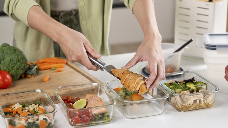 hands dole out food into meal prep containers
