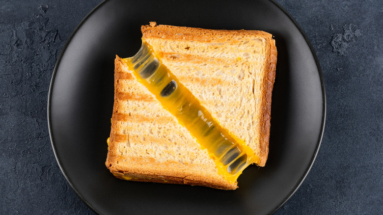 A grilled cheese sandwich on a black plate