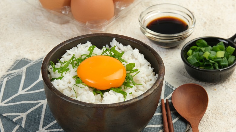 Close-up of a raw egg in a bowl of cooked rice