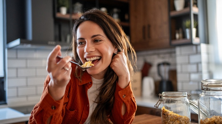 woman eats a bowl of cereal with milk