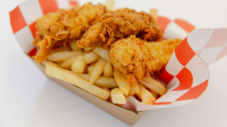 fast food chicken strips with fries in basket