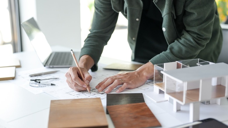 designer works on plans atop desk