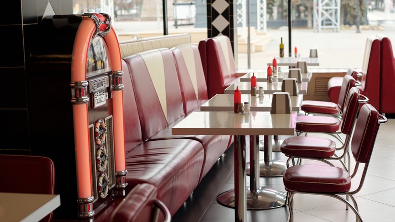 A vintage diner interior with red leather seats and a jukebox