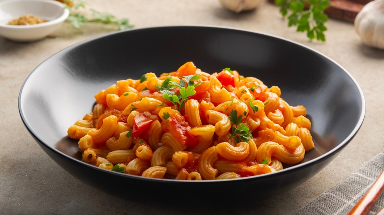 A bowl of macaroni with tomatoes