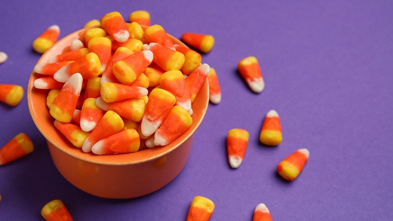 candy corn in bowl purple background