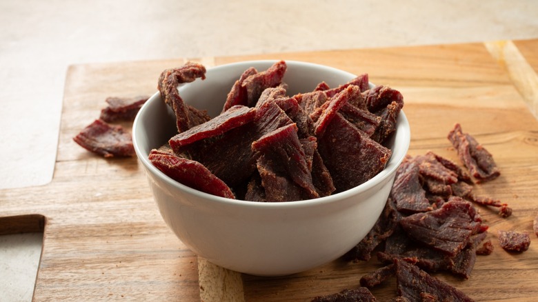 bowl of beef jerky with cutting board