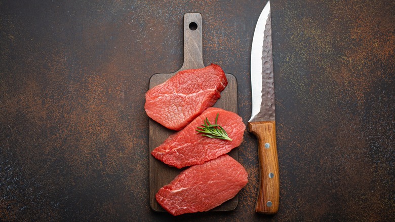 sirlon steaks on board with a knife