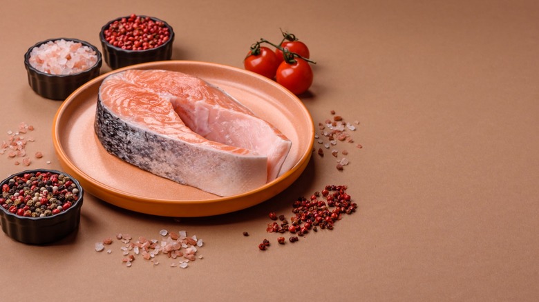 raw salmon filet with spices and accompaniments