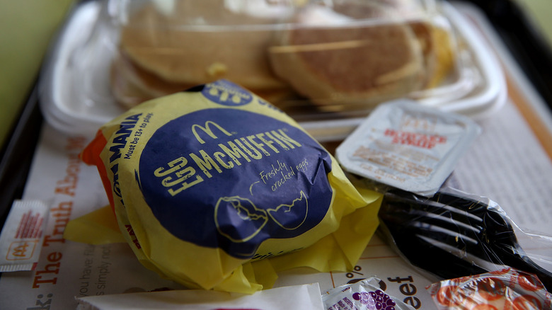 Egg McMuffin in branded wrapper on tray, closeup.