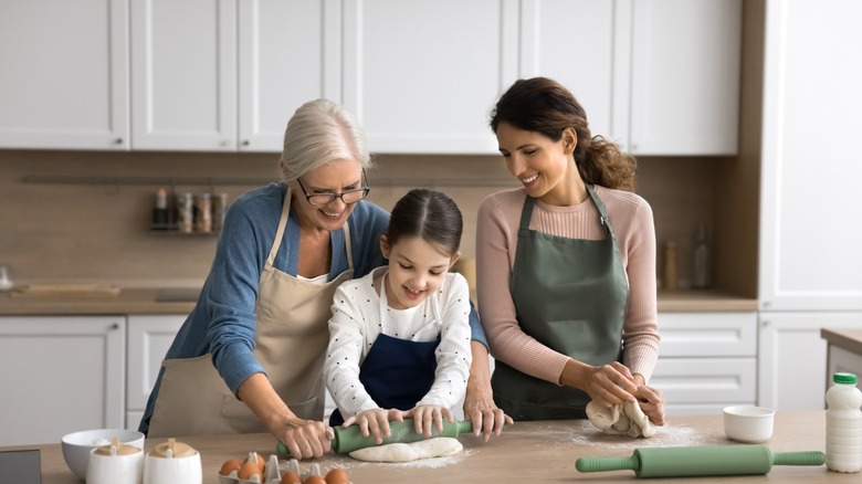 family rolls pie dough in kitchen