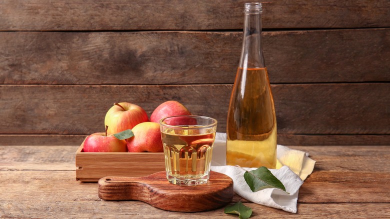 fresh cider with apples and rustic background
