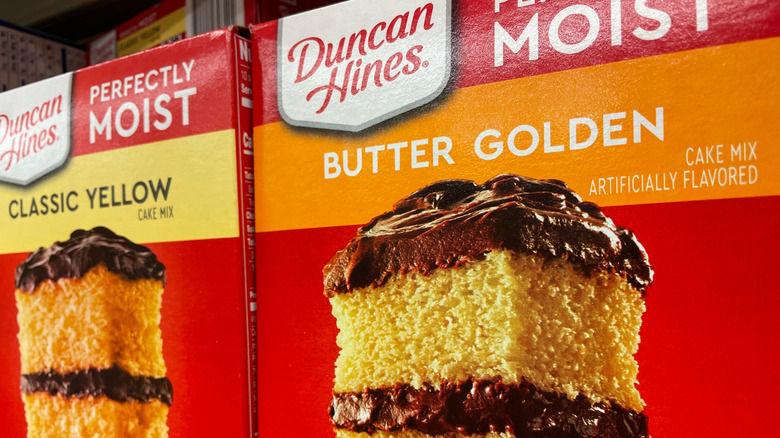 duncan hines classic yellow and butter golden cake mixes next to each other on grocery store shelf