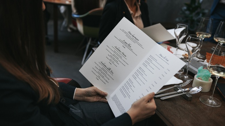 woman looks at a restaurant menu
