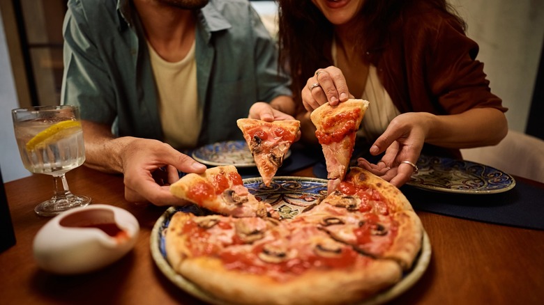 two people eat pizza together