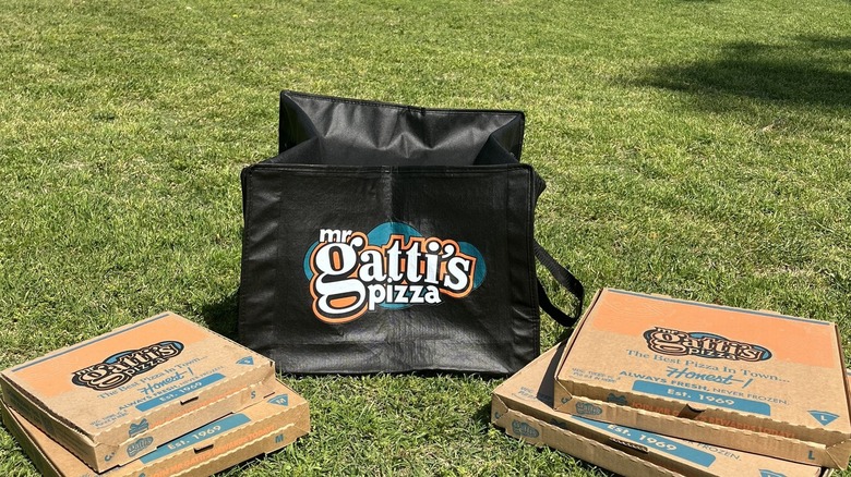 pizza boxes on the grass with hot bag