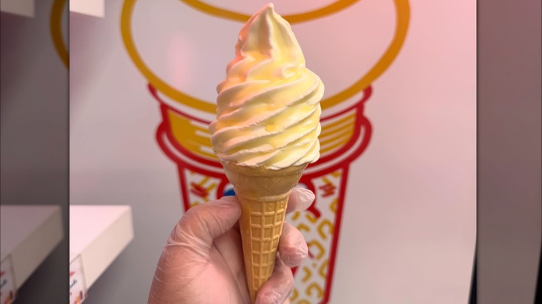 butter dipped soft serve cone being held in hand