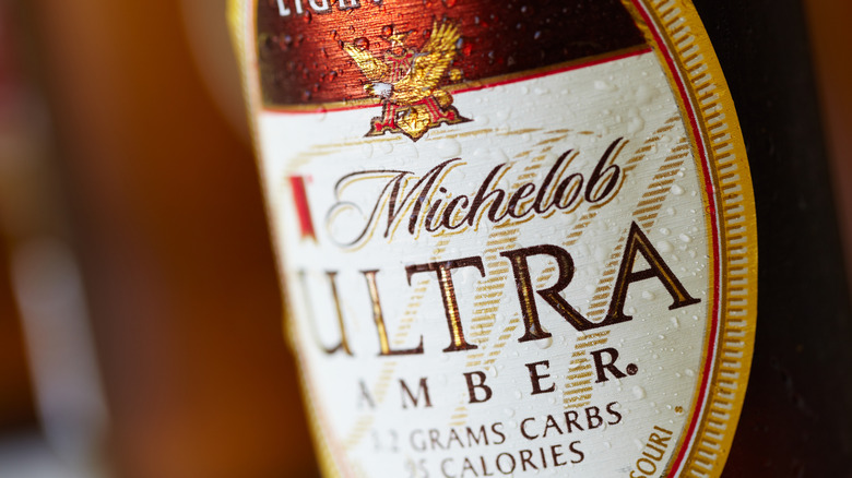 Closeup of a Michelob ULTRA glass bottle with label.