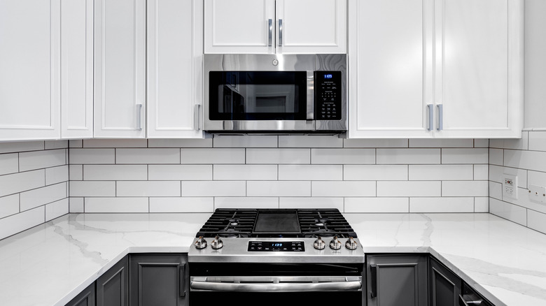 A GE microwave and oven in stark white kitchen