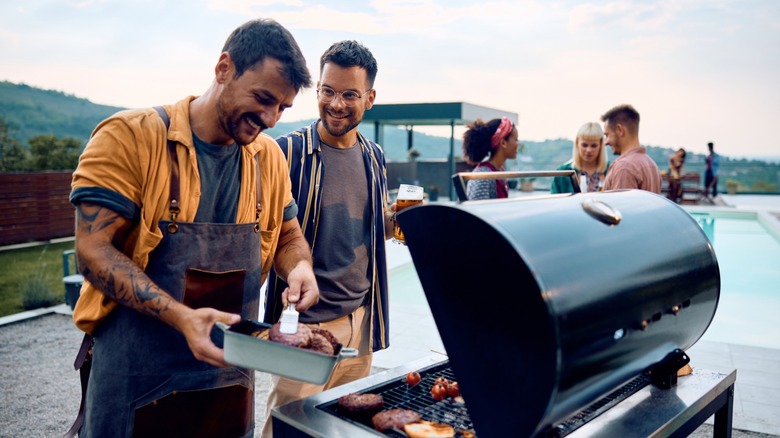 friends prepare burgers on the grill