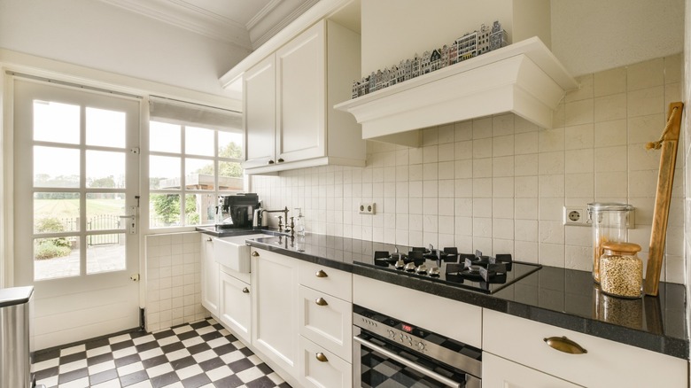 a bright white kitchen with checkerboard flooring