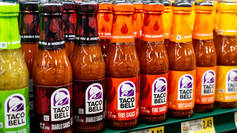 Bottles of Taco Bell hot sauce on a supermarket shelf
