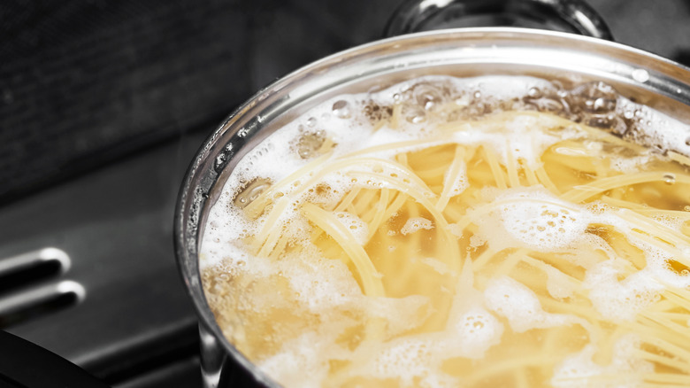 Spaghetti cooking in a pot of boiling water