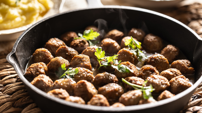 A pan of meatballs garnished with parsley.