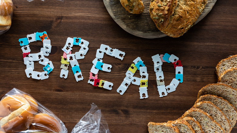 Bread clips spelling "bread" on wooden table with bread slices