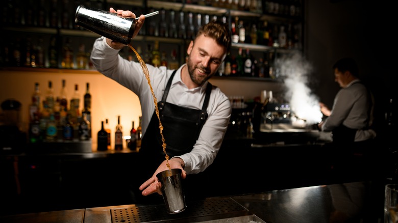 Bartender throwing cocktail from one tin to another