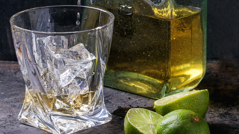 Tequila bottle next to glass with ice