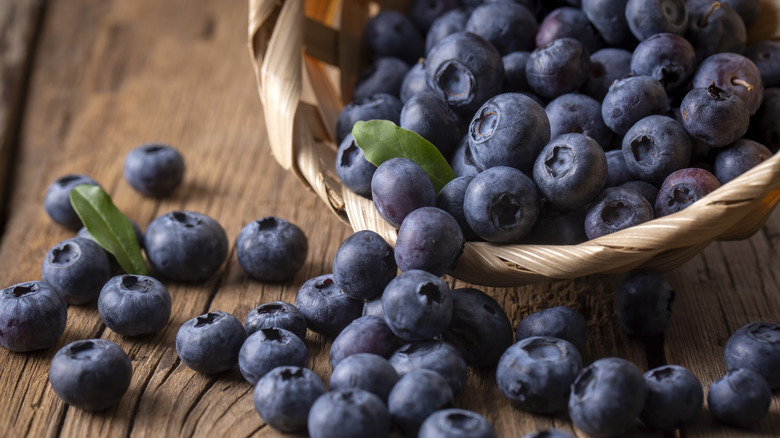 Blueberries spilling from a basket onto a table
