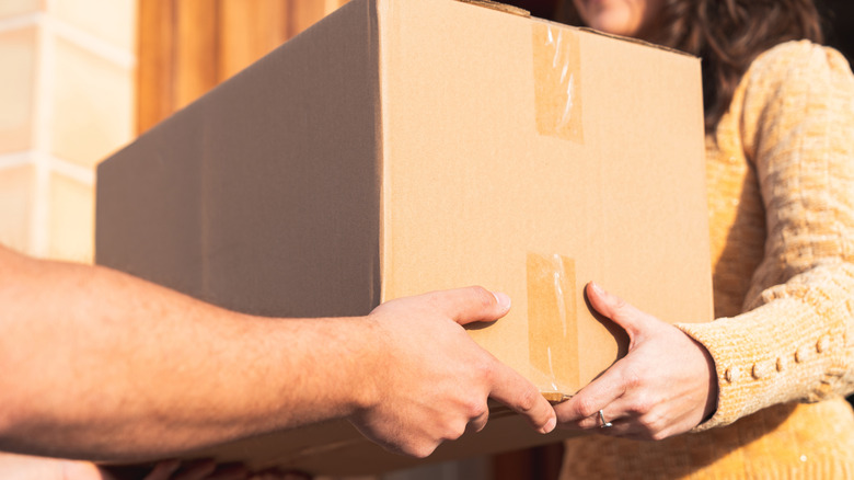 Close-up handing box from one person to another
