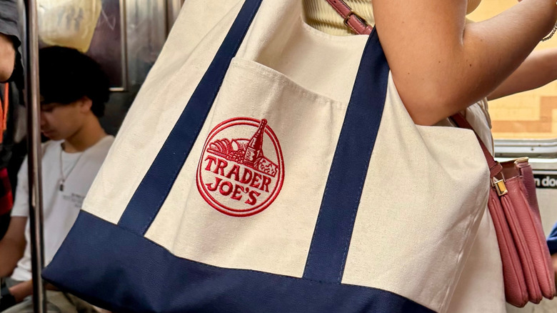 Close-up of a woman carrying a Trader Joe's tote bag