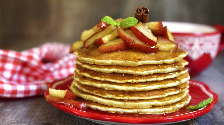 stack of cinnamon pancakes with apples and syrup