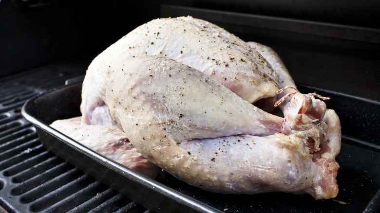 Raw turkey, seasoned and ready for cooking in a gas barbecue