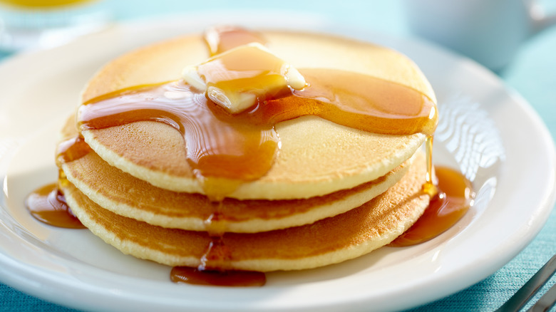 plate of pancakes topped with maple syrup