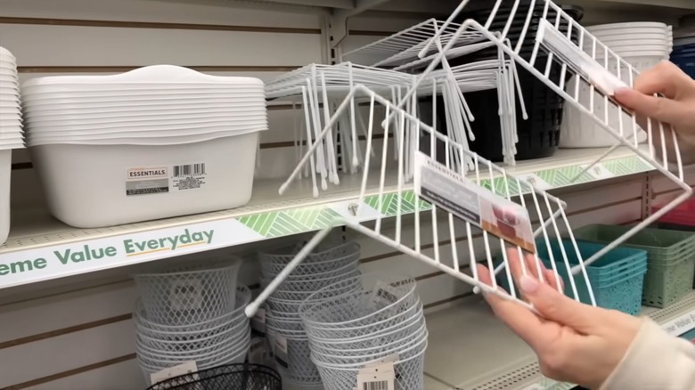 hands pull wire racks off a shelf at dollar tree