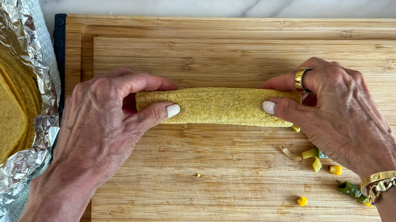 hands rolling up enchilada