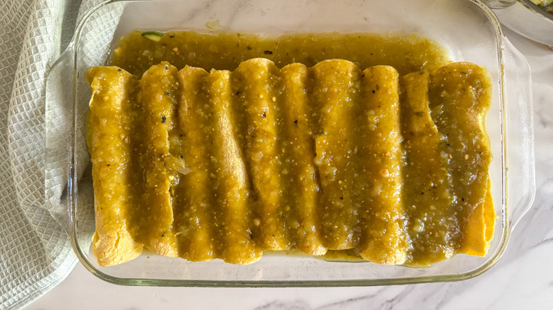 enchiladas covered in salsa verde in baking dish