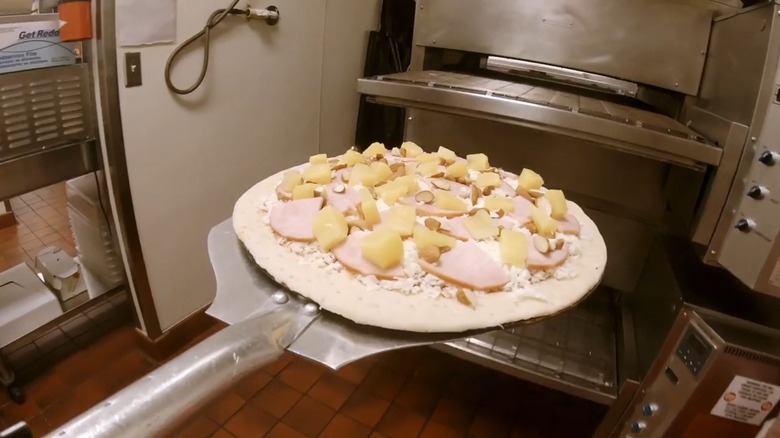 hawaiian pizza with almonds on pizza skid