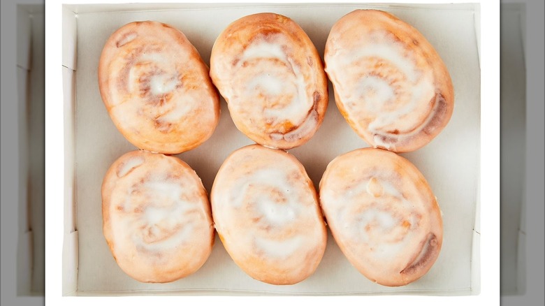 half dozen cinnamon donuts in cardboard box